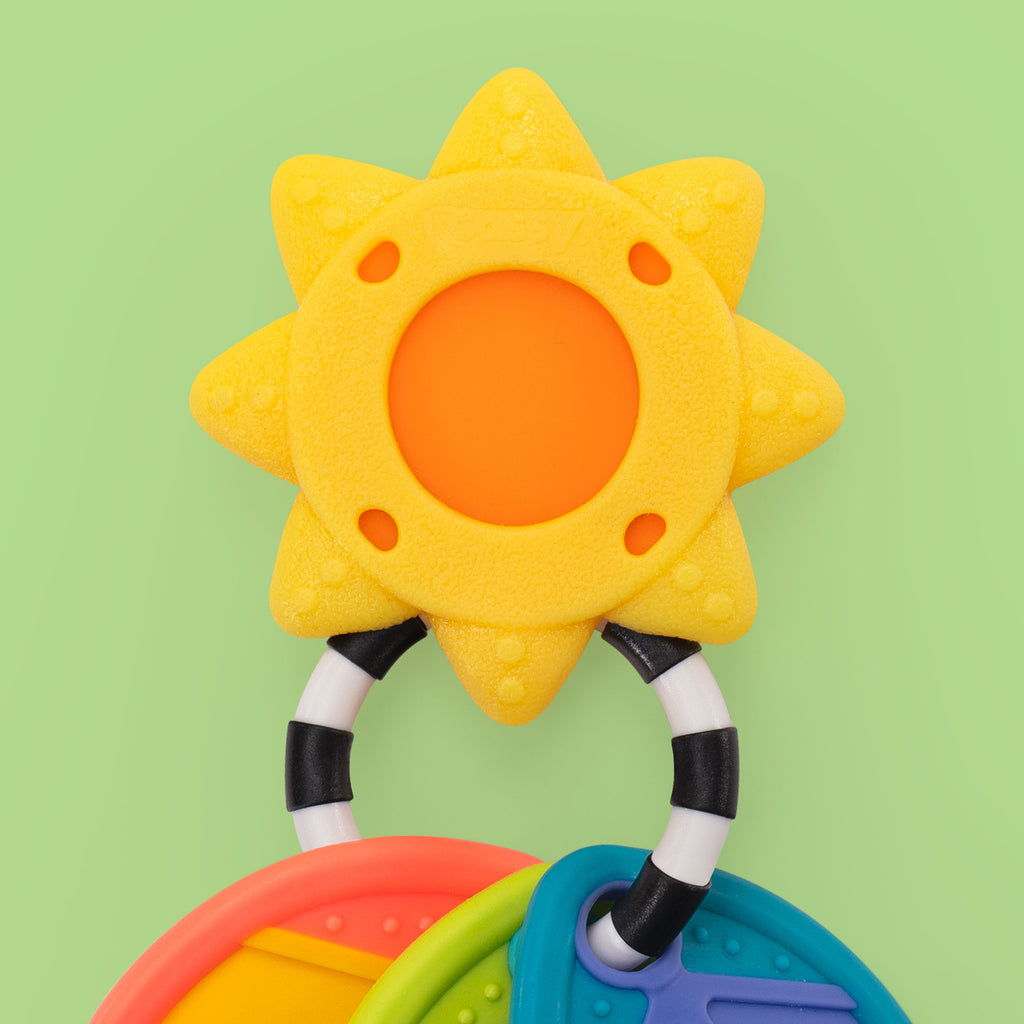sunshine shaped teether on a green background.