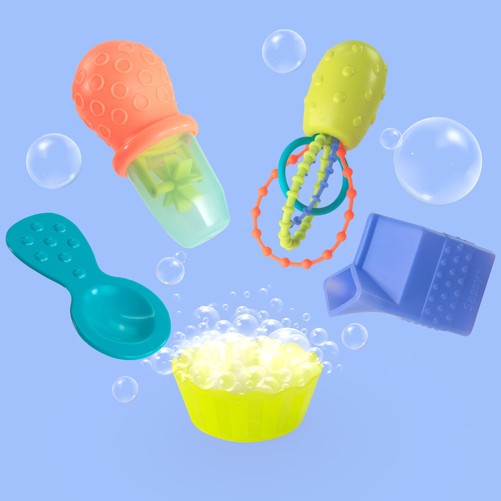 5 baby bath toys: blue spoon, green bowl, purple milk carton, multicolored whisk, and orange and green baster in use