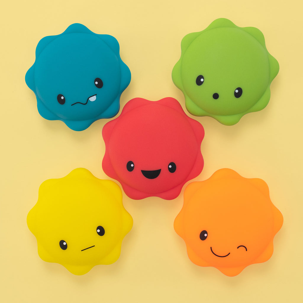 5 piece macaron bath toy overhead on a yellow background