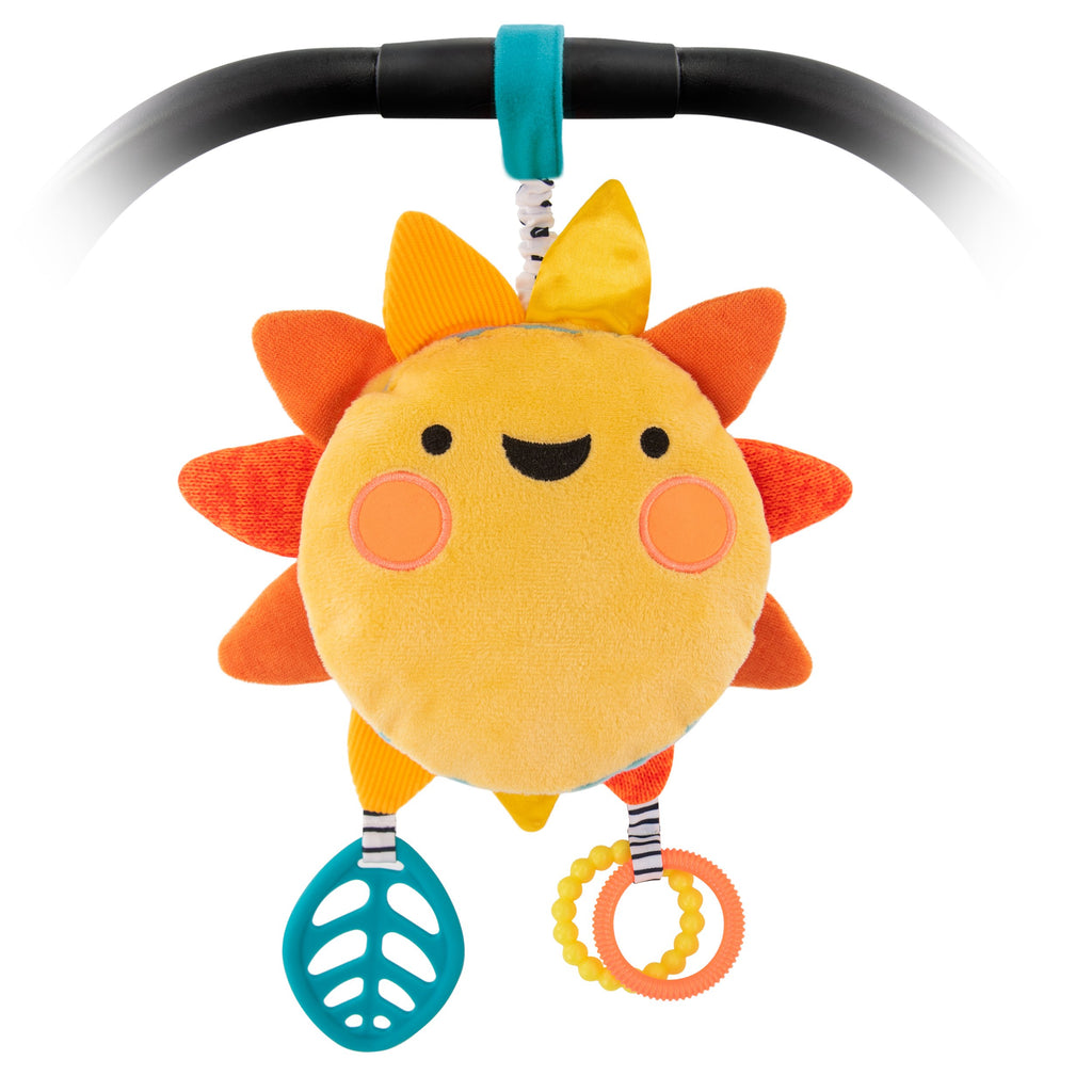 Smiling plush sunshine with leaf teether and click clack rings, and attachable velcro n a baby carrier handle.