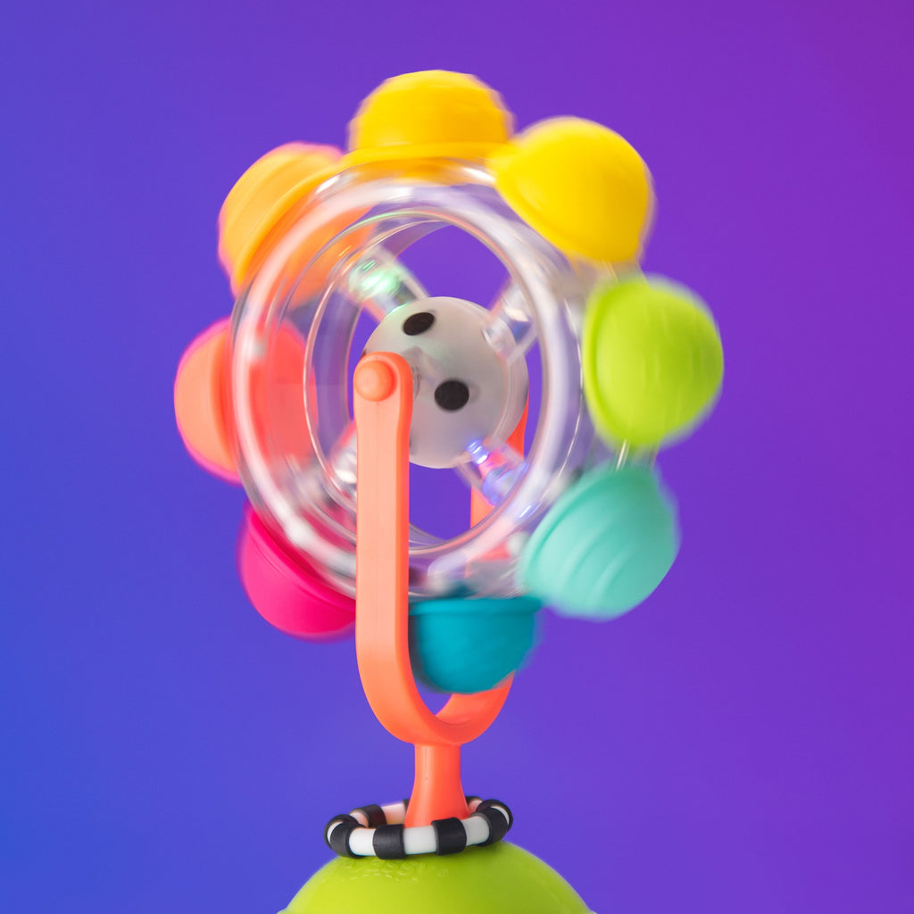 spinning wheel tray toy with multicolored bumps, attached to a suction base.