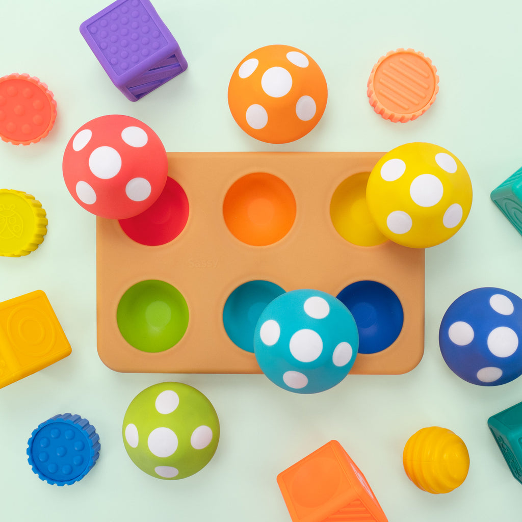 overhead view of matching mushroom board, and assorted blocks and STEM toys on a teal background. 