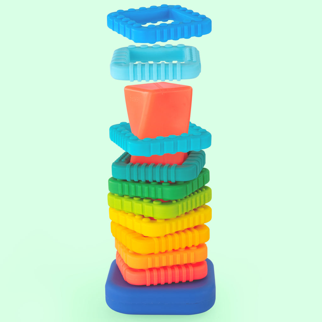 a ring stacker with a blue base and a pink/red post that is twisted. there are 10 different bright colored and textured rings in rainbow order. 