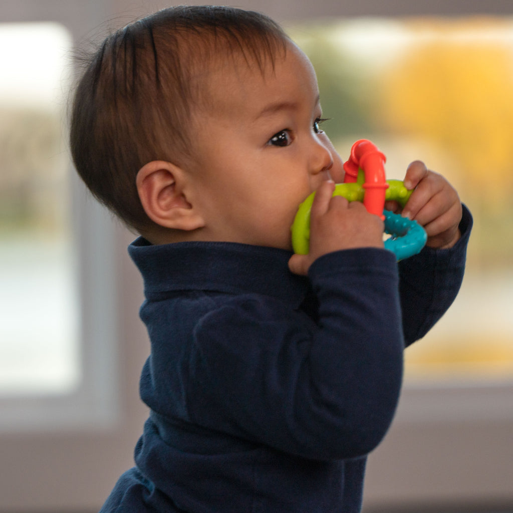 infant holding and teething on sassy triple loop teether